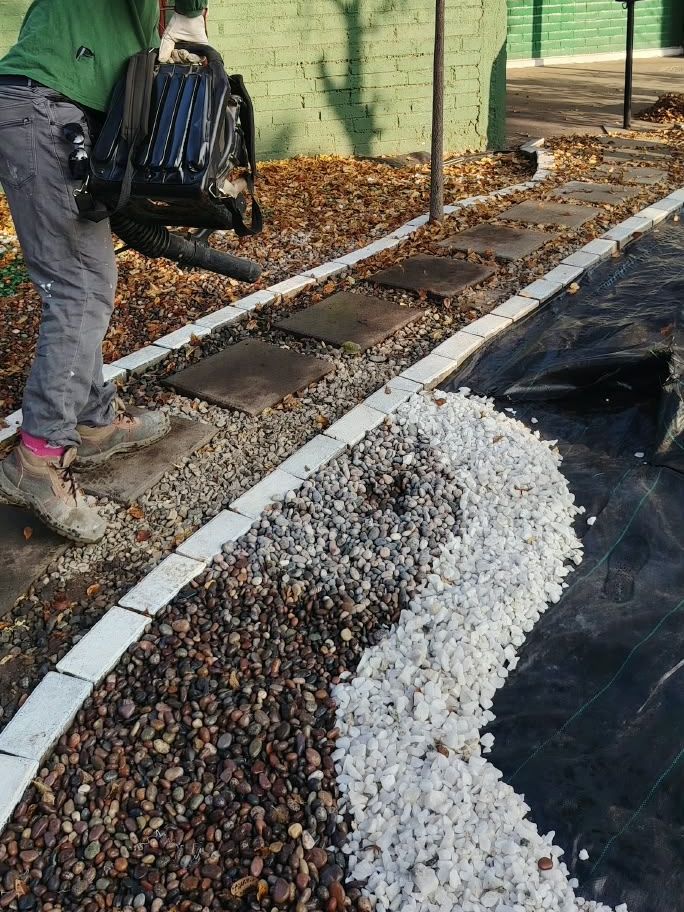 Área verde con sendero de gravilla y piedras instalada por Coopera Pro.